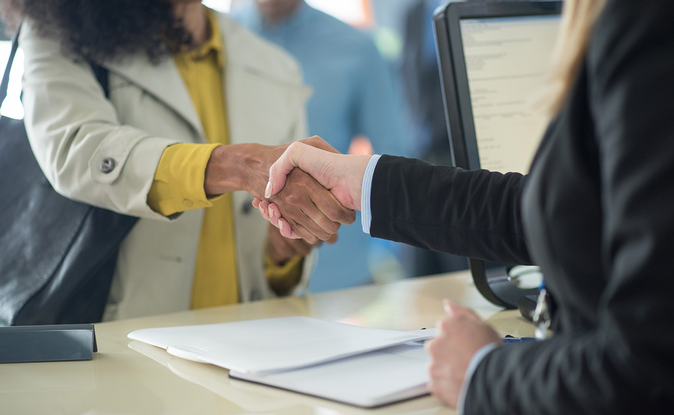 hands shaking above tan desk with documents