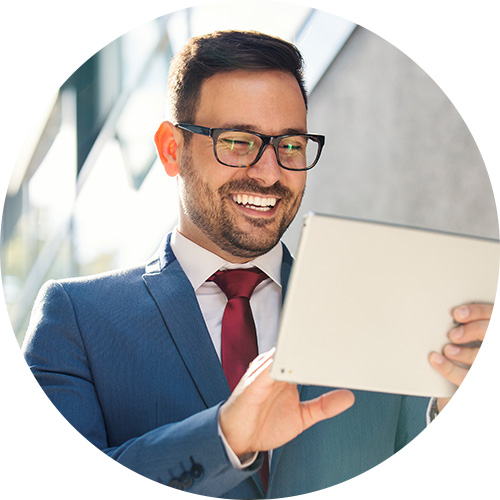 Businessman smiling at a tablet.