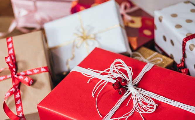 Image of gift boxes wrapped in white, red, and brown parchment paper.