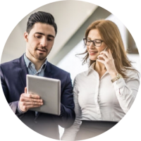 Business Checking Businessman and businesswoman use a silver tablet.